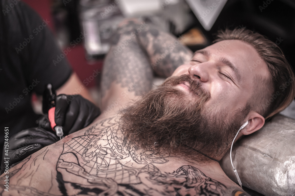 Master working tattooing in tattoo studio Master working tattooing in tattoo studio