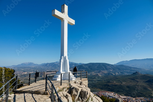 Large white stone cross on the hill of Santa Catalina in Jaén (Spain) and its views over mountains of crops photo