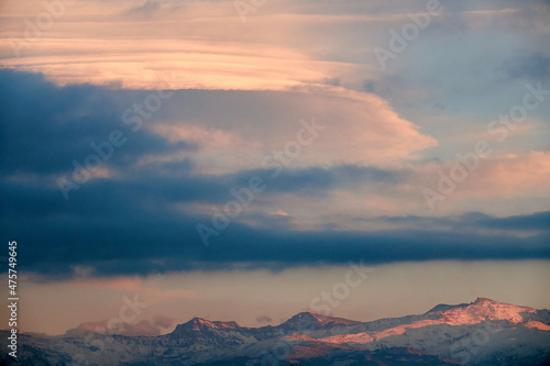 Huge white lenticular clouds over Sierra Nevada in Granada at sunset