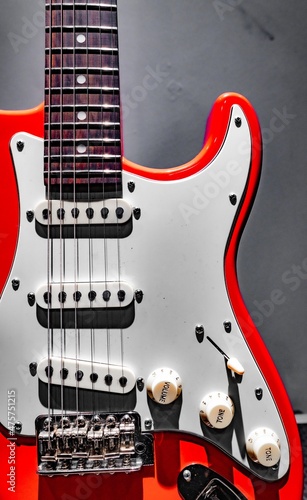 Red electric guitar fretboard and body on gray background photo