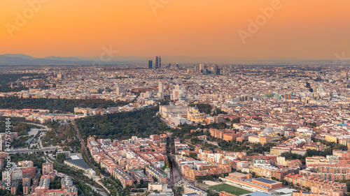 Aerial views of the city of Madrid during sunset on a clear day, being able to observe the five towers, the financial center, the Almudena cathedral, the Royal Palace and Madrid Río photo