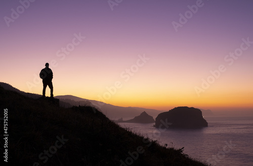 Man at sunset and San Juan de Gaztelugatxe from Matxitxako cape, Euskadi