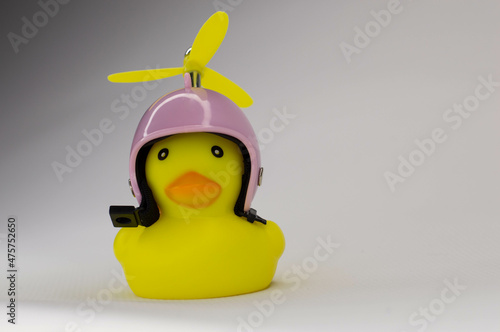 yellow rubber duck on white background in pink helmet with yellow propeller