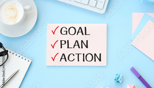 2022 New Year. Goal,plan, action text on notepad with office accessories on a wooden background. Business motivation, inspection concepts ideas.
