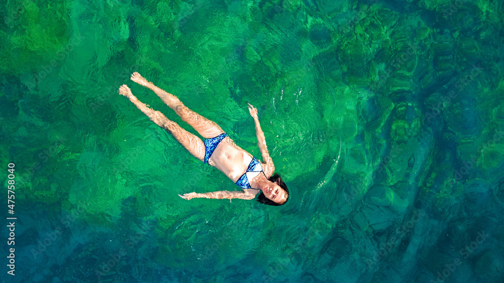 Φωτογραφία Young woman swimming in blue sea lagoon in crystal clear water, girl in bikini s
