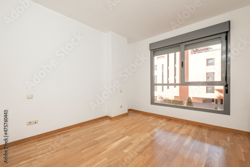 Empty room with large window  oak parquet floor in a rental apartment