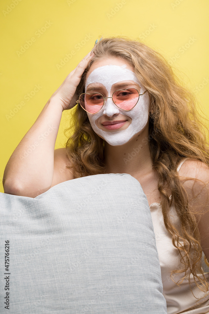 The girl makes procedures with a cosmetic mask on her face. The girl makes procedures with a cosmetic mask on her face.