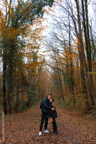 A lovely couple hug each other in nature. they strike a pose. Very romantic photo in autumn forest. 