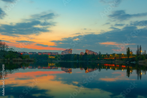 Landscape of a lake surrounded by buildings and lights in the evening in Chisinau, Moldova photo