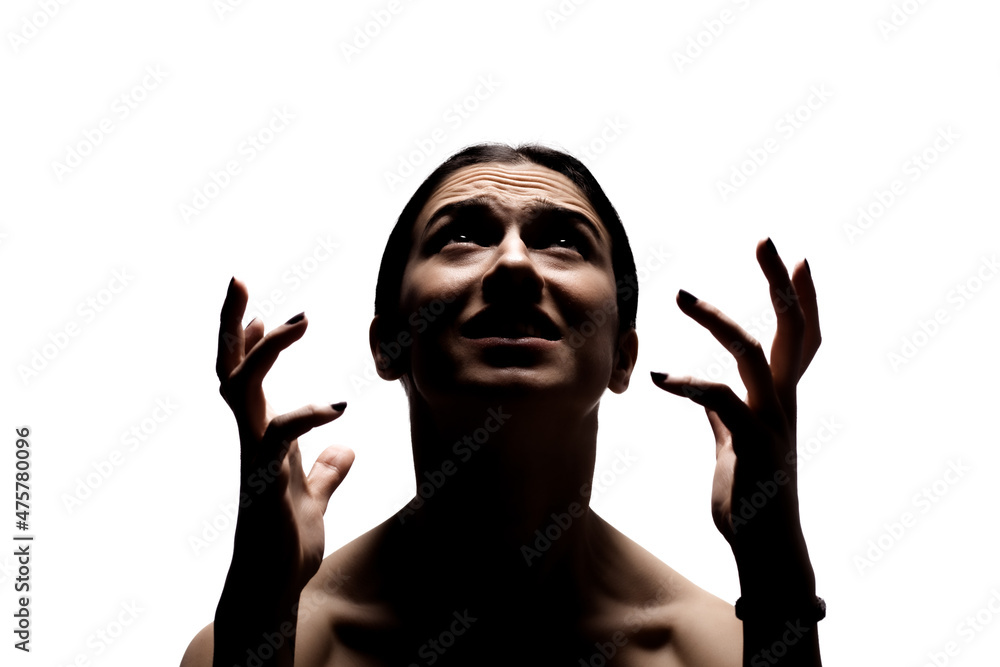 Dark half silhouette portrait with shadows of an angry girl looking up making gestures with her hands. Dark half silhouette portrait with shadows of an angry girl looking up making gestures with her hands.