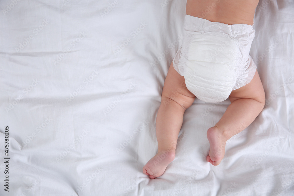 Top view of cute baby in dry soft diaper on white bed. Space for text Top view of cute baby in dry soft diaper on white bed. Space for text
