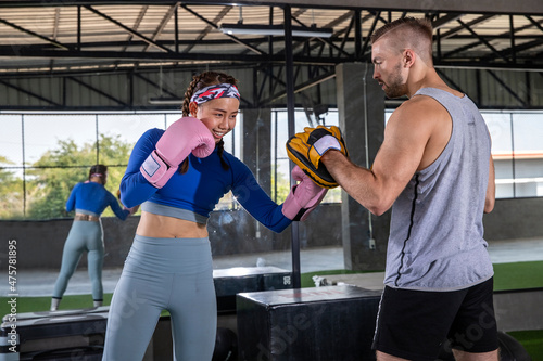 sport woman practicing kickboxing with her coach.