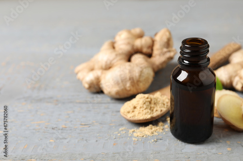 Ginger essential oil in bottle on light grey table. Space for text