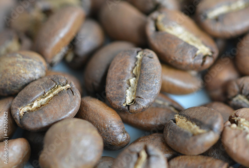 Close up view of roasted arabica coffee beans on a blurred coffee background © Eko