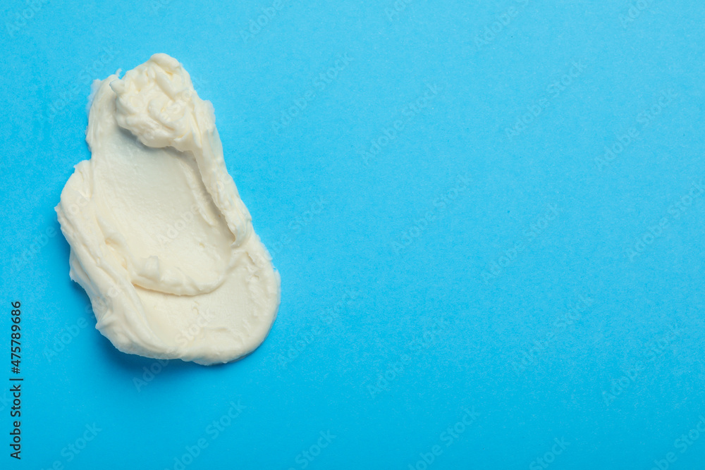 Smear of delicious cream cheese on light blue background, top view. Space for text Smear of delicious cream cheese on light blue background, top view. Space for text