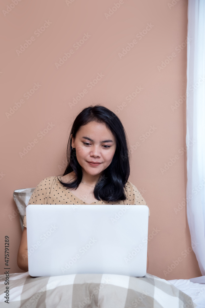 Beautiful woman working with laptop in bed