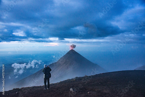 Climber on Acatenango watching Fuego volcano erupting, Antigua, Guatemala © raquelm.