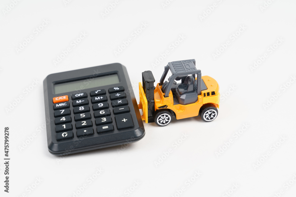 Business and economy concept. A toy loader carries a calculator. Business and economy concept. A toy loader carries a calculator.