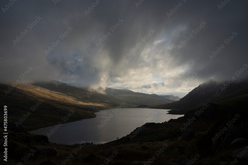 Epic early Autumn Fall landscape of view along Ogwen Valley in Snowdonia National Park under dramatic evening sky with copy space