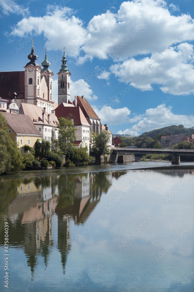 View of Österreichisches Weihnachtsmuseum and its reflection in the Steyr river from Museumssteg bridge.
