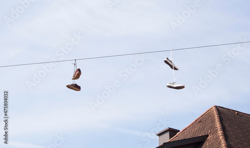 Two pairs of sneakers hanging by its laces on cables of the street lighting in Steyr, Austria.