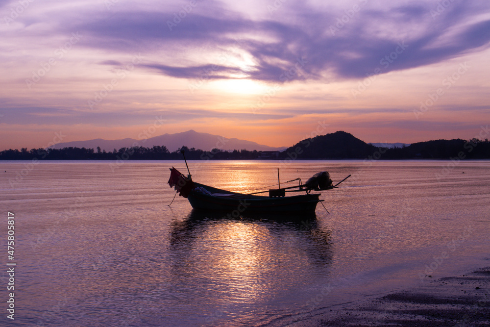 boat of fisherman on the beach with silhouette light before sunset and mountain background Asia Thailand