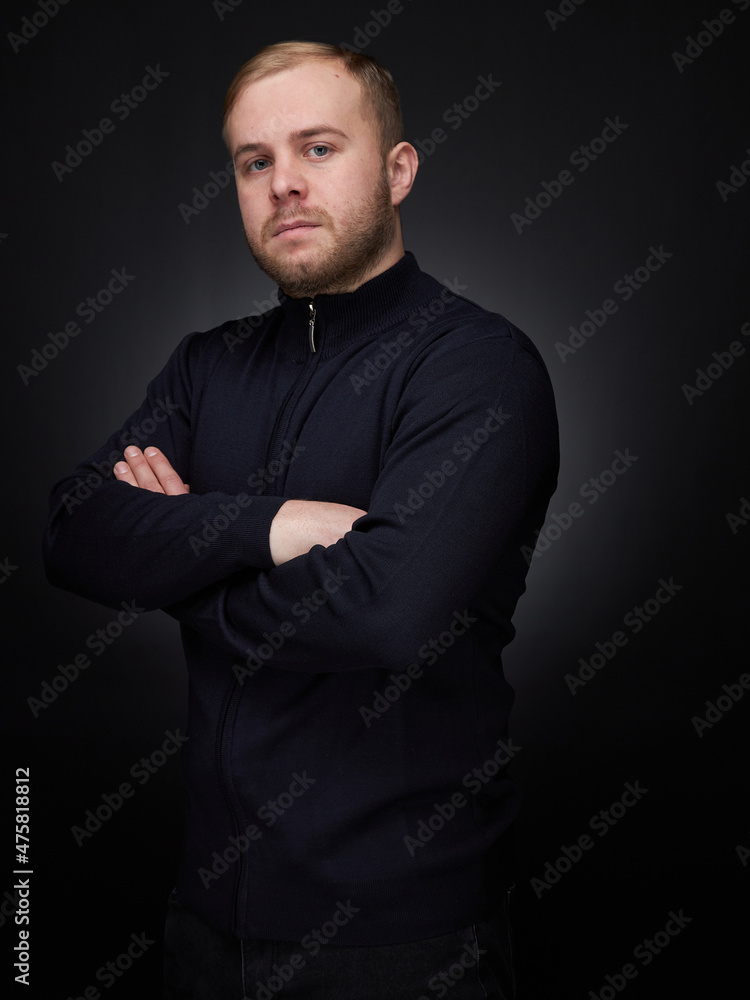 vertical portrait  blond man on a dark background, in a jacket