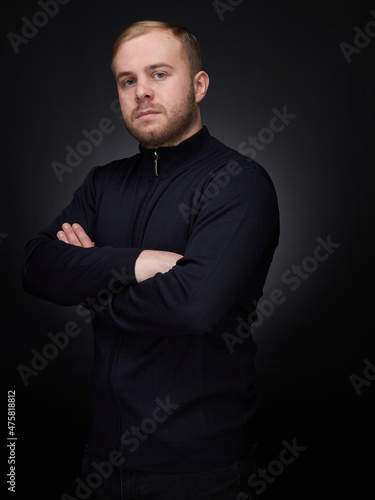 vertical portrait blond man on a dark background, in a jacket