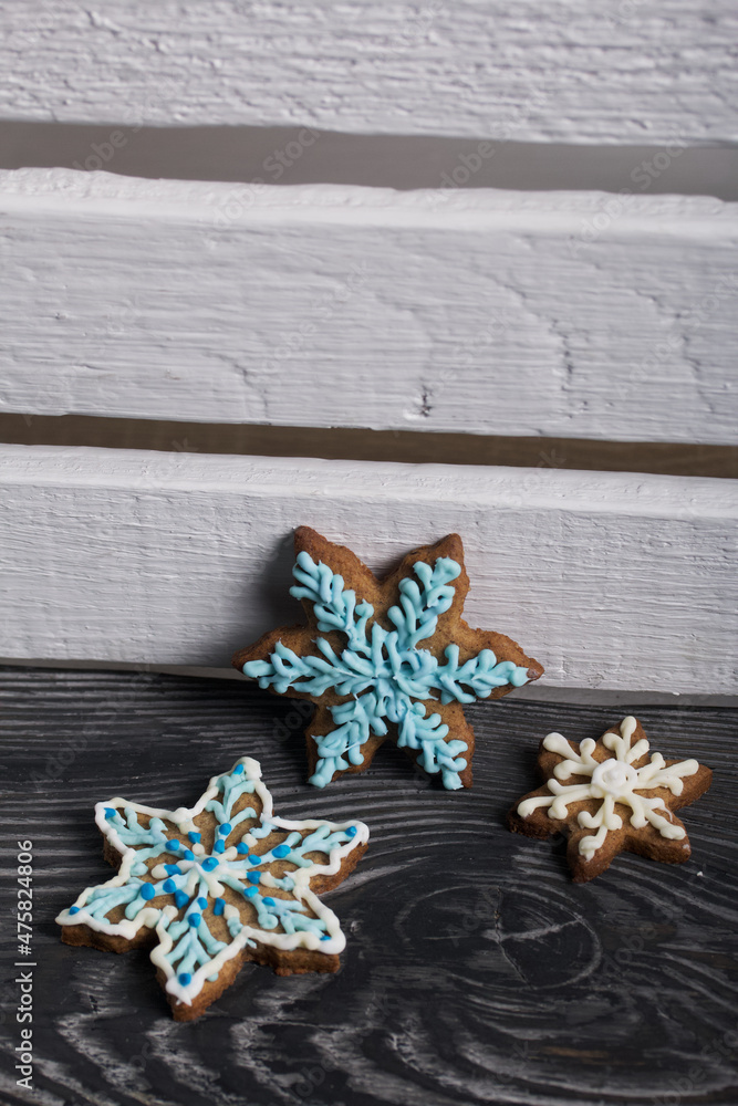 Gingerbread cookies in the shape of a snowflake. Decorated with sugar glaze. Gingerbread cookies in the shape of a snowflake. Lie on black boards. Close-up shot. Gingerbread cookies in the shape of a snowflake. Decorated with sugar glaze. Gingerbread cookies in the shape of a snowflake. Lie on black boards. Close-up shot.