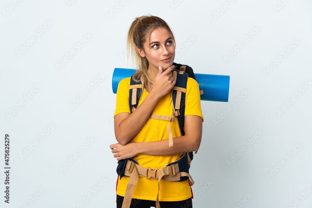 Young mountaineer woman with a big backpack isolated on white background looking to the side and smiling Young mountaineer woman with a big backpack isolated on white background looking to the side and smiling