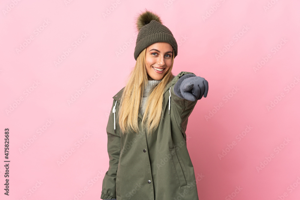 Young woman with winter hat isolated on pink background pointing front with happy expression Young woman with winter hat isolated on pink background pointing front with happy expression