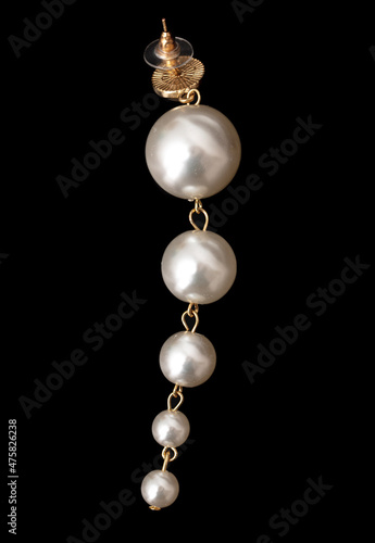 Earrings with pearls on a black background.