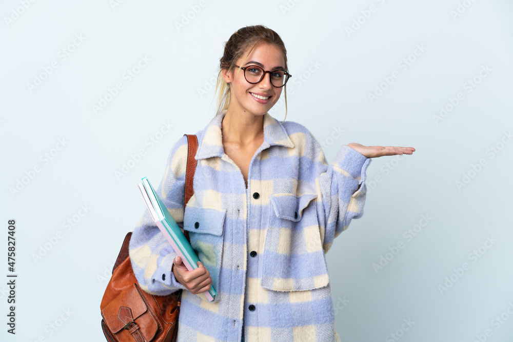 Young student woman isolated on white background holding copyspace imaginary on the palm to insert an ad Young student woman isolated on white background holding copyspace imaginary on the palm to insert an ad