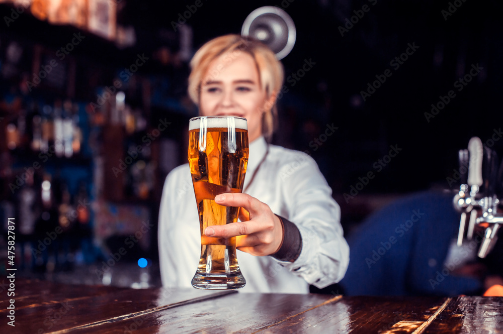 Girl bartender makes a cocktail behind the bar