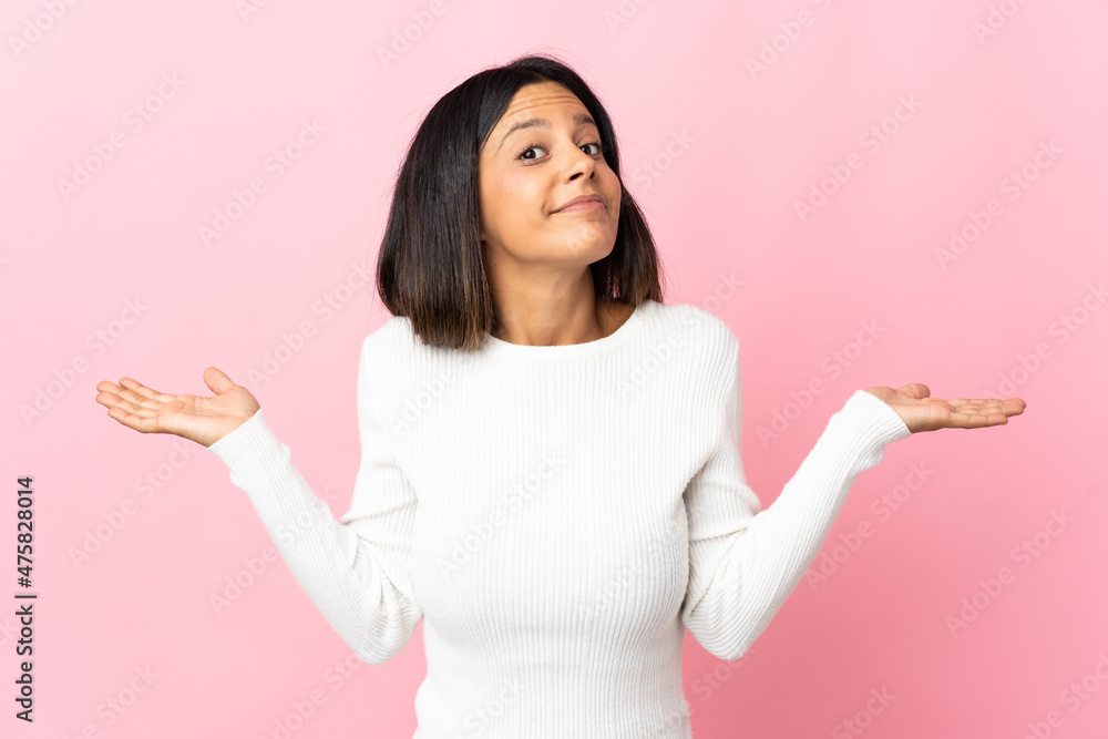 Caucasian girl isolated on pink background making doubts gesture Caucasian girl isolated on pink background making doubts gesture