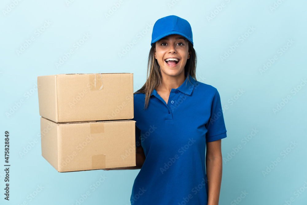 Young delivery woman isolated on blue background with surprise facial expression Young delivery woman isolated on blue background with surprise facial expression
