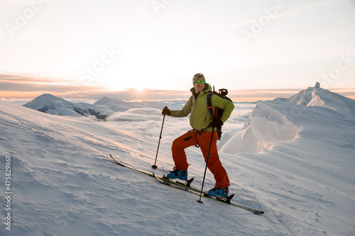 Smiling male skier against the backdrop of the beautiful sky and sunrise