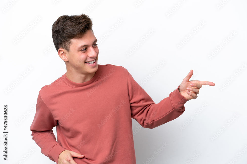 Young handsome Brazilian man isolated on white background pointing finger to the side and presenting a product Young handsome Brazilian man isolated on white background pointing finger to the side and presenting a product