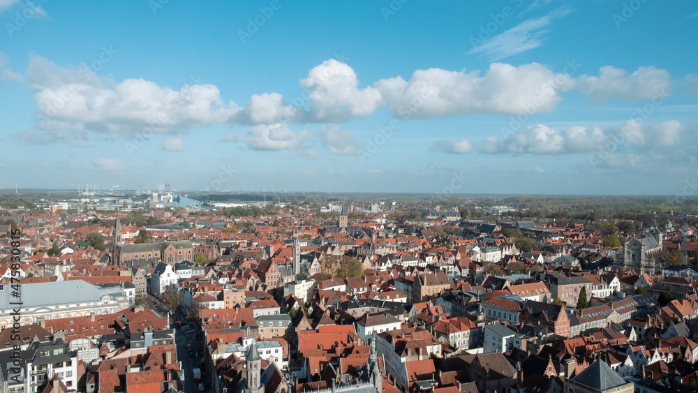 cityscape of Bruges, with red ceiling and the Church tower