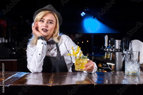 Charming girl bartending demonstrates his skills over the counter photo