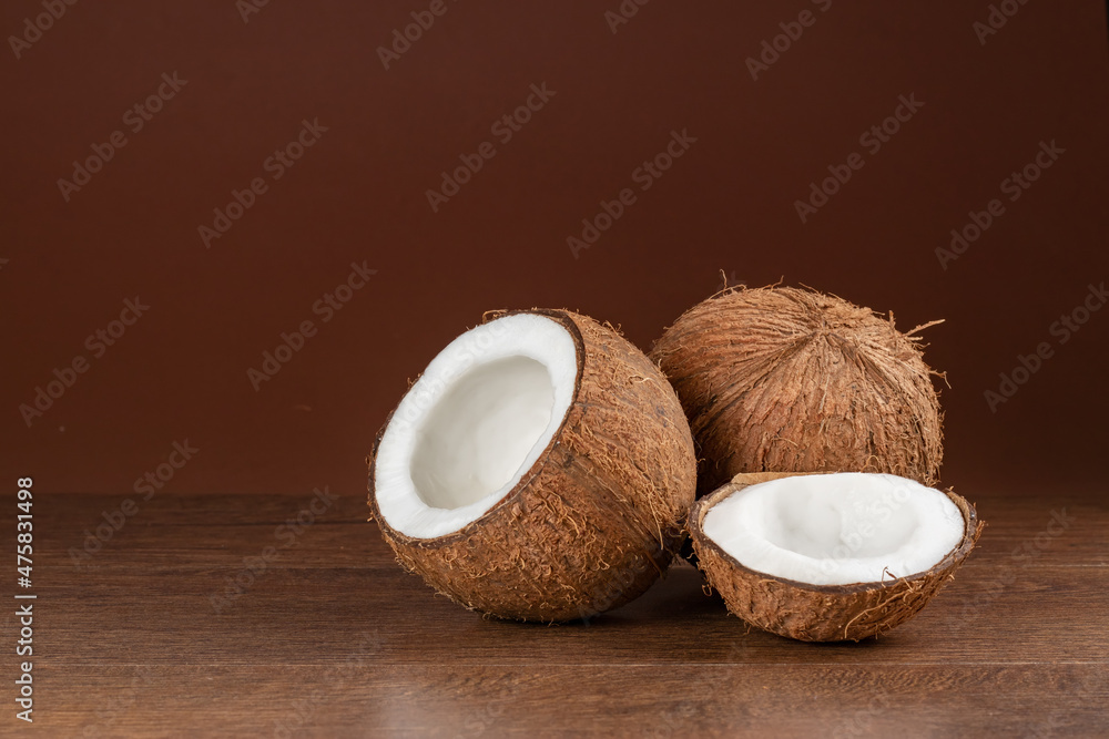 Coconut with half on brown background Coconut with half on brown background