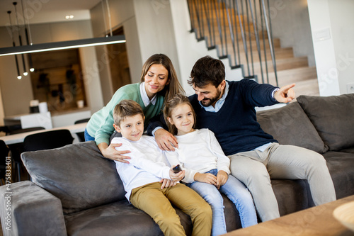 Young family watching TV together on the sofa in the living room