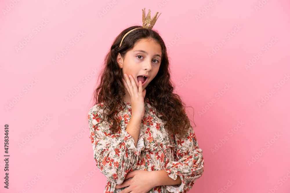 Little caucasian princess with crown isolated on pink background with surprise expression Little caucasian princess with crown isolated on pink background with surprise expression