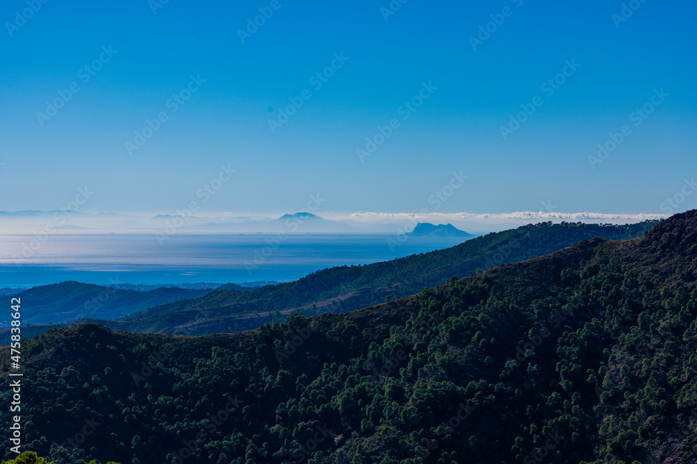 paisaje de montaña con el mar al fondo a contraluz Ojén Andalucía España	