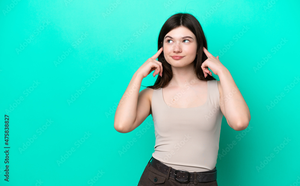 Young Russian woman isolated on green background having doubts and thinking Young Russian woman isolated on green background having doubts and thinking