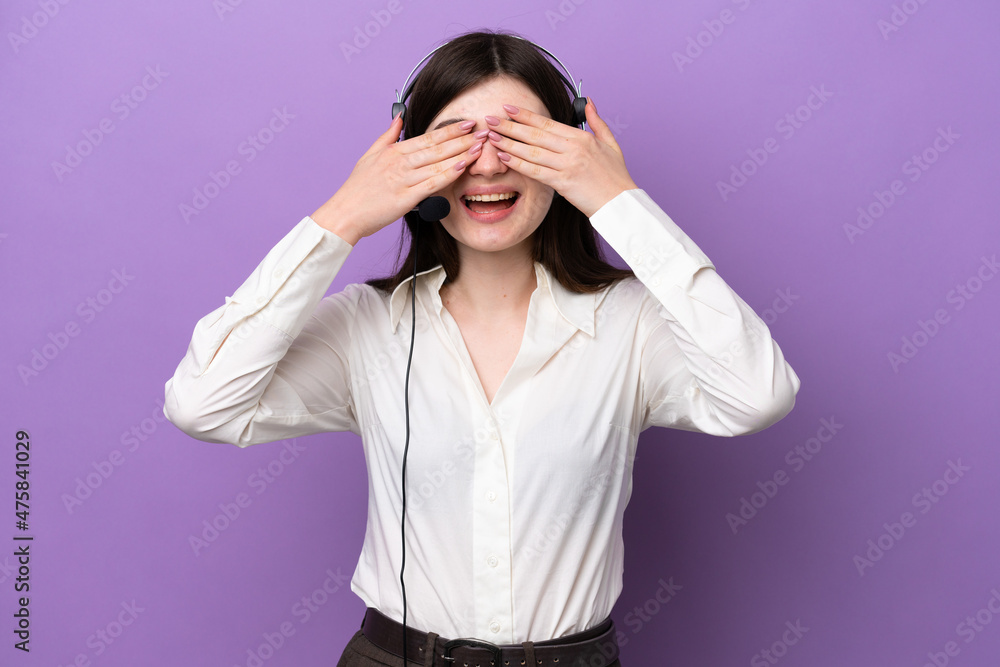 Telemarketer Russian woman working with a headset isolated on purple background covering eyes by hands Telemarketer Russian woman working with a headset isolated on purple background covering eyes by hands