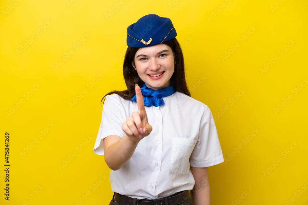 Airplane stewardess Russian woman isolated on yellow background showing and lifting a finger Airplane stewardess Russian woman isolated on yellow background showing and lifting a finger