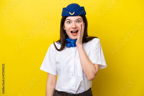 Airplane stewardess Russian woman isolated on yellow background with surprise and shocked facial expression