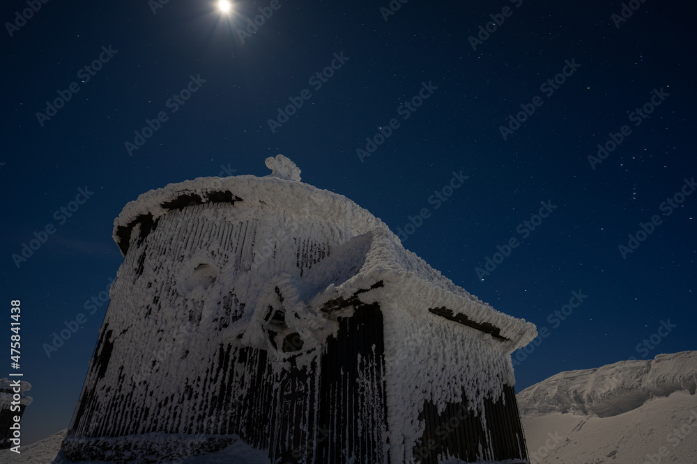chapel on Snezka mountain at moon winter night in Giant mountains