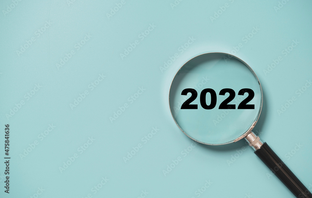 2022 year number insider of magnifier glass on blue background for focus new year business concept. 2022 year number insider of magnifier glass on blue background for focus new year business concept.